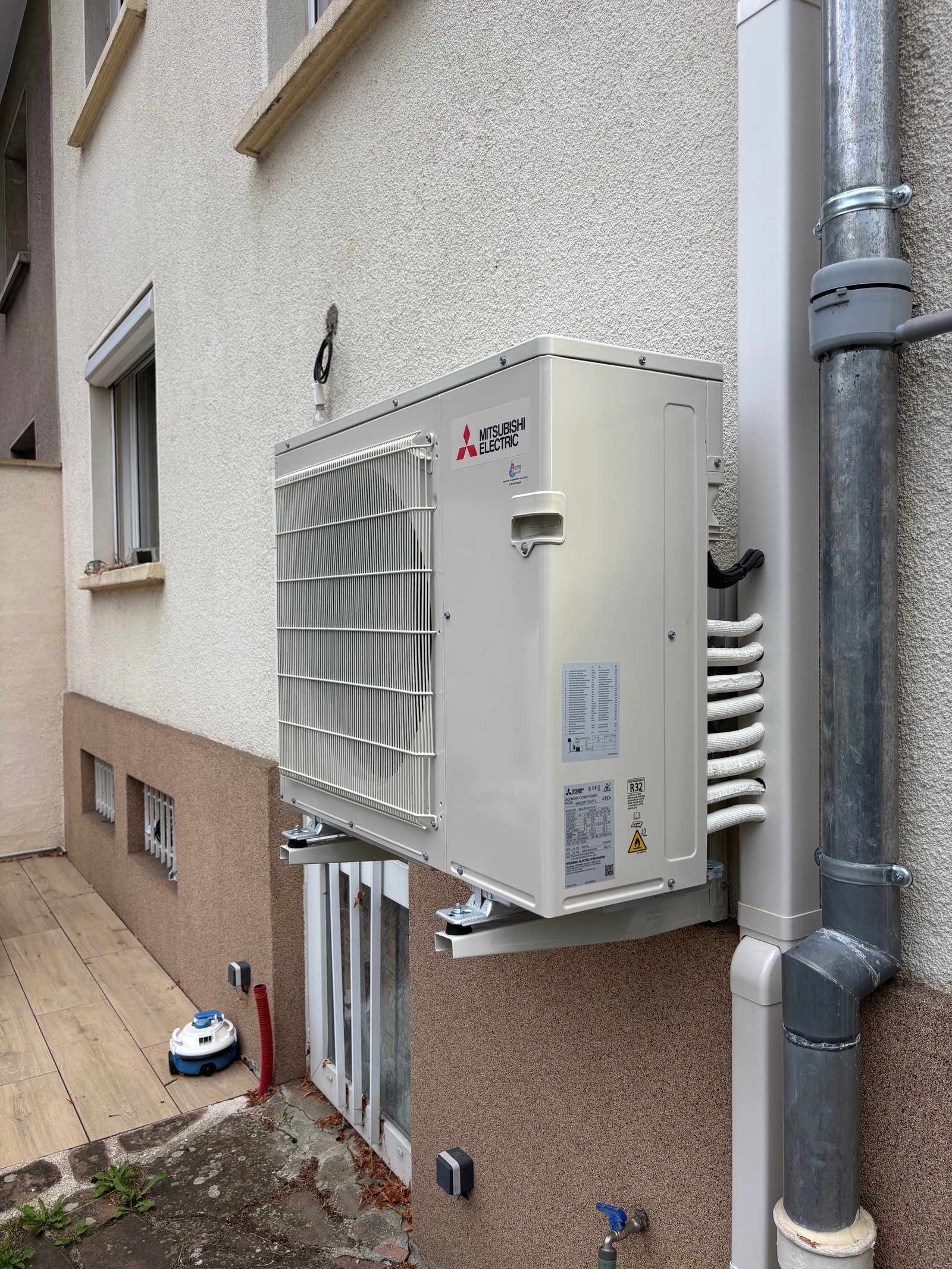 Groupe extérieur de climatisation Mitsubishi installé sur support mural